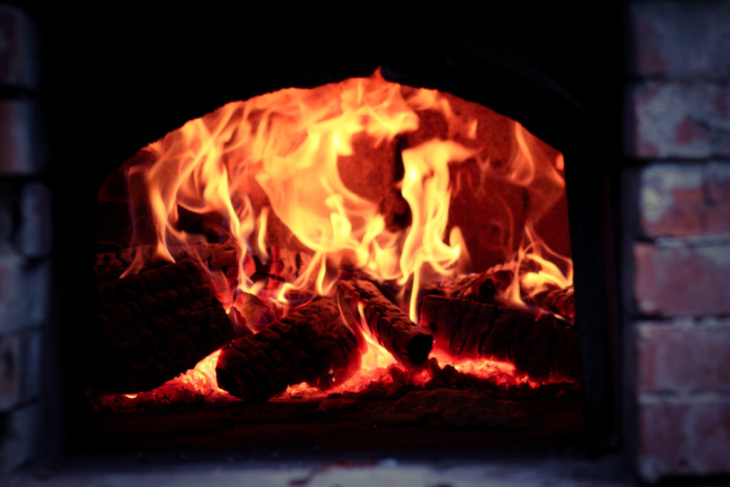 A buring fire in a little pizza oven